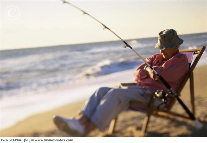 senior_man_relaxing_in_a_chair_with_a_fishing_rod_1574r-014947e.jpg