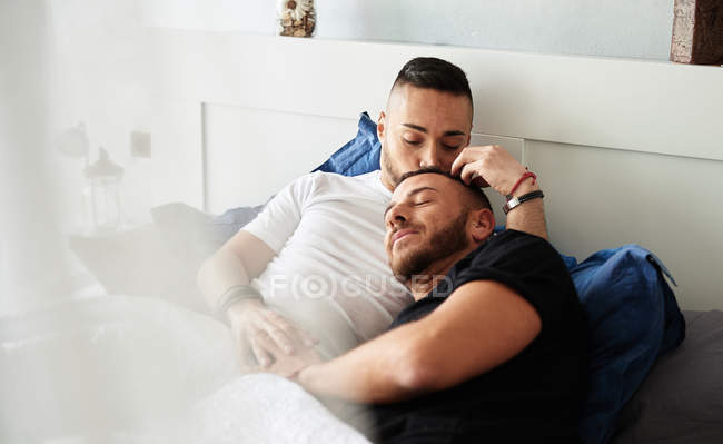 focused_285614444-stock-photo-cheerful-homosexual-men-lying-bed.jpg