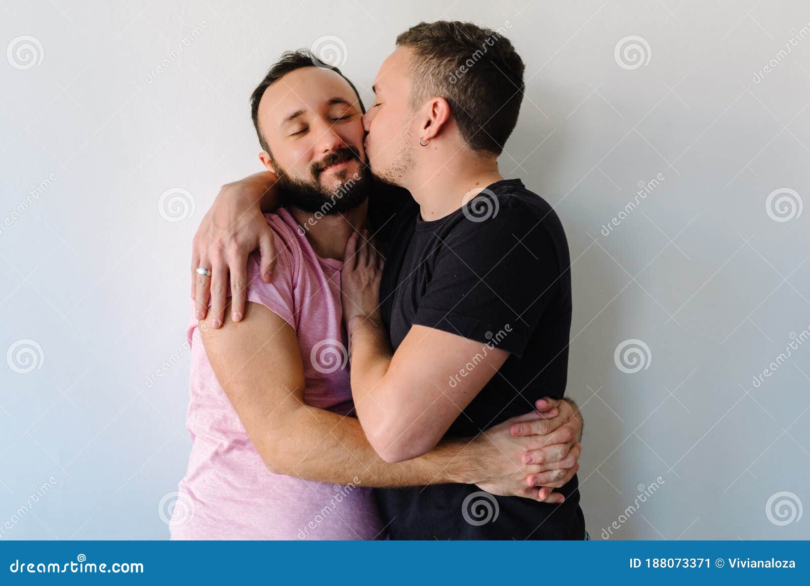 stock-photo-two-caucasian-homosexual-men-kissing-their-apartment-one-them-hugging-other-behind-gay-man-each-188073371.jpg