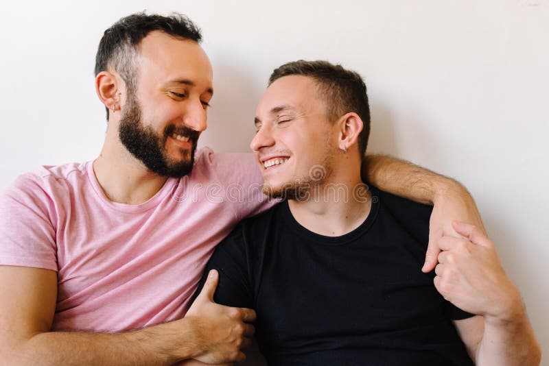 gay-couple-laughing-home-stock-photo-two-caucasian-homosexual-men-smiling-their-apartment-one-them-hugging-188809520.jpg